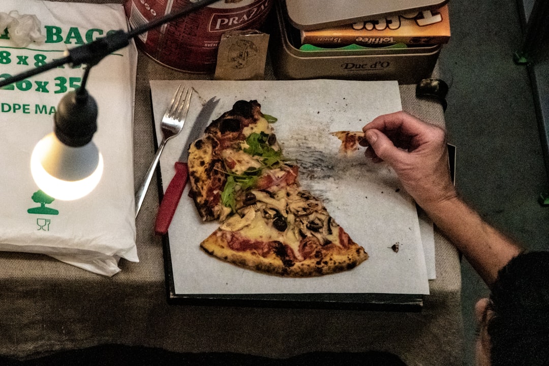 Prosciutto being laid on a pizza